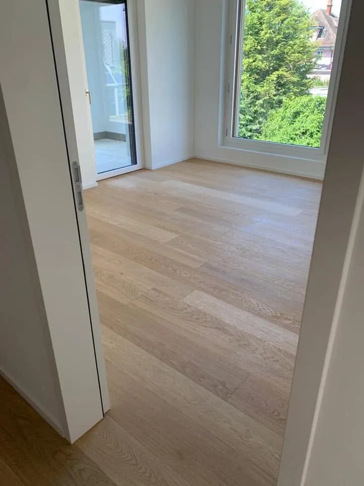 Helles Zimmer mit frisch verlegtem Eichenparkett und Blick ins Grüne